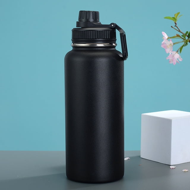 TAL Bouteille d'Eau Ranger Pro à Double Paroi Isolée en Acier Inoxydable, 40 Oz, Fini Noir Mat avec Couvercle et Poignée Durables pour un Transport Facile. Idéale pour le Rangement des Boissons et la Rétention de la Température, Placée sur une surface Grise avec un Fond Bleu et des Éléments Décoratifs.
