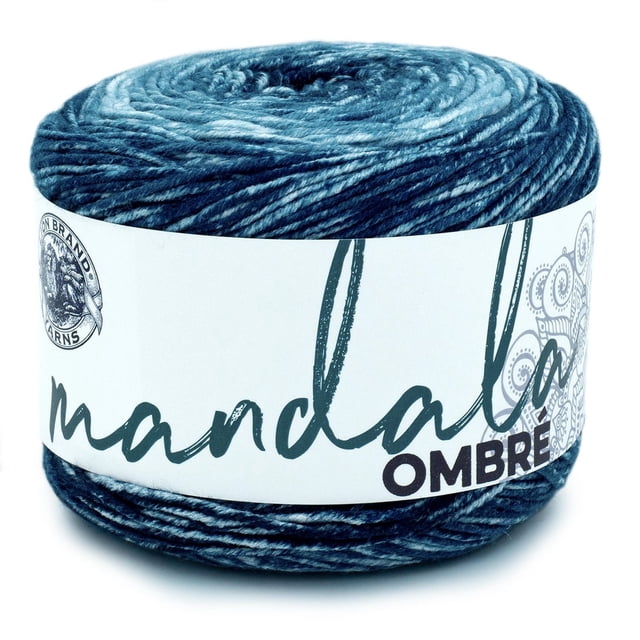 Lion Brand Yarn Mandala Ombre Harmony Yarn, medium weight 4 acrylic yarn in a 344-yard cake, showing a blue ombre gradient from light to dark shades, wrapped with a white label featuring the product name and brand logo, suitable for knitting and crochet projects.