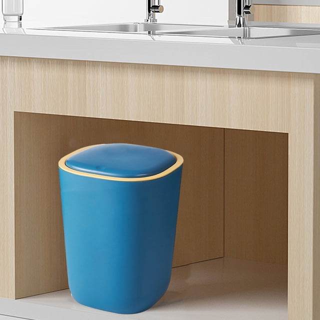 Silent Opening and Closing Lid Trash Can for bathroom, bedroom, office, or dormitory use. Made of durable blue plastic with a compact size of 23.2x19x30cm (9.13x7.48x11.81in). Features a one-click lid opening mechanism, silent and slow lid lifting, and a pressing ring design to secure garbage bags. Shown placed under a sink in a modern setting.