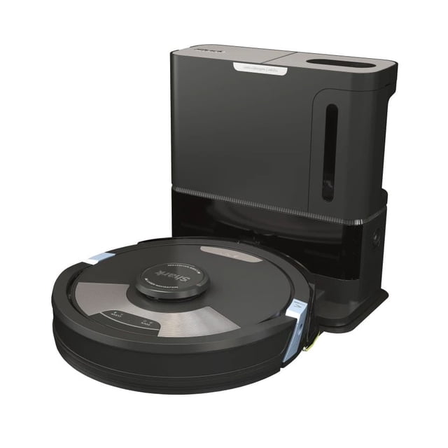 Shark Matrix™ Plus 2-in-1 Self-Empty Robot Vacuum and Mop in a 3/4 front view showing a round black vacuum with silver accents and a top sensor, positioned next to its tall black self-emptying base station with a dustbin window, designed for whole home vacuuming and sonic mopping with HEPA filtration.