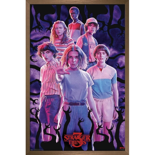 Netflix Stranger Things : Saison 3 - Affiche Murale de Groupe Mettant en Vedette six Personnages en Vêtements des Années 1980, Arrangée en formation Triangulaire sur Fond Violet Foncé avec des Ombres Noires Type Griffes. l'Affiche Brillante Mesure 14,725 par 22,375 Pouces et Est Encadrée en Bois Foncé avec le logo Rouge Stranger Things au Bas. Idéale pour Décorer des Chambres, des Bureaux Ou des Dortoirs.