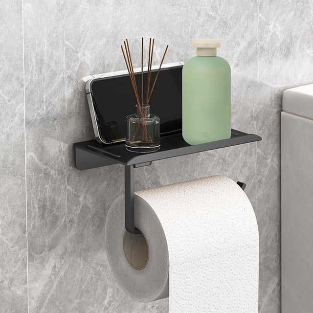 FcBaudy bathroom tissue holder in black, designed for holding toilet paper rolls and featuring a top shelf for storing small items like a phone or bottle. Made of durable, rust-resistant plastic, it is mounted on a marble wall using adhesive backing. Compact and versatile, suitable for bathrooms, RVs, or laundry rooms, and provides additional storage space.