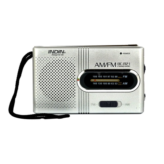 Radios Portable AM FM with a compact design featuring a silver finish. This transistor radio includes a built-in high-performance loudspeaker for clear sound and an earphone jack for private listening. The front panel displays an AM/FM frequency dial, and the device is powered by two AA batteries, making it ideal for travel, camping, or emergencies. A black wrist strap is attached for portability.