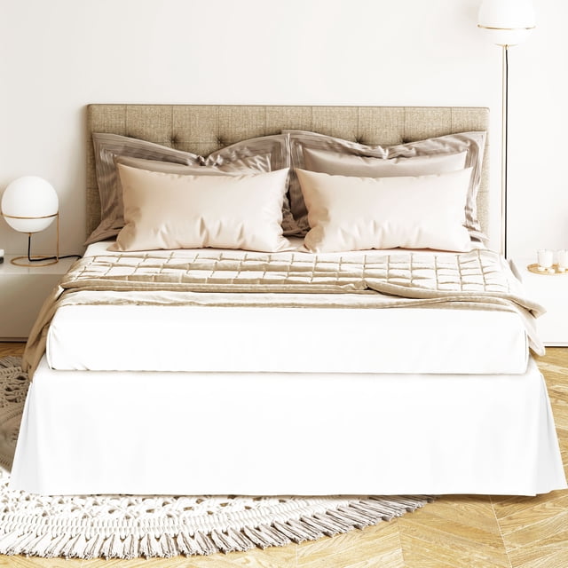PiccoCasa Bed Skirt Double Brushed Microfiber with Dust Ruffle in Queen size, shown in snow white. Made of 110 gsm microfiber, it features a 16-inch drop that reaches the floor, hiding under-bed storage. The tailored design includes corner pleats for a modern look, secured with elastic bands at all four corners for stability. Displayed in a neutral bedroom setting with beige bedding and a tufted headboard.