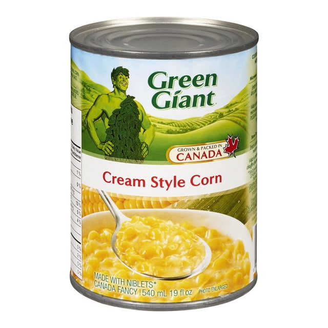 Géant Vert Maïs en Conserve Style Crème avec une Cuillère d'Engrais de Maïs Jaune Crémeux, le logo Géant Vert et une Feuille d'Érable Canadienne Indiquant Qu'il Est Cultivé et Emballé au Canada. la Taille de la Conserve Est de 540 ml (19 fl oz).