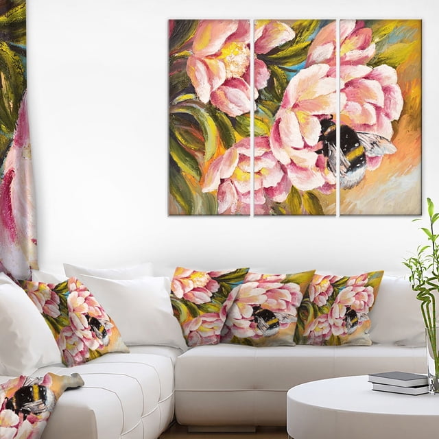 Design Art Bee Sitting on Flower Canvas Print featuring a gallery wrapped cotton canvas triptych with a close-up of a bumblebee on pink flowers and green leaves, displayed above a white sectional sofa with matching cushions, suitable for enhancing home décor with vibrant wall art.