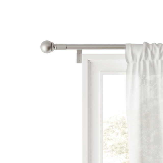 Mainstays Easy Install Decorative Window Curtain Rod in brushed nickel finish, adjustable from 48 to 120 inches, mounted above a white window frame with a sheer white curtain panel. The 0.75-inch diameter rod features a round ball finial and hidden brackets for secure installation, suitable for standard curtains and panels.