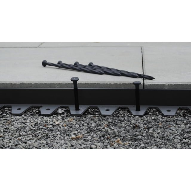 Bordure de Pavillon Flexi-Pro Installée avec Piquets Métalliques Noirs le Long d'Un Lit de Gravier à Côté de Pavillons en Béton, Conçue pour une installation Facile par Technoflex International, Idéale pour les Bords d'Entretien de Jardin et de Pelouse dans les Aires de Vie Extérieures.