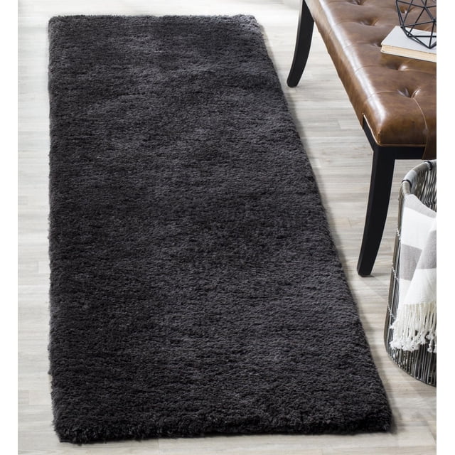 Safavieh Sheep Shag Sybella Tapis en Peluche Uni Couleur Charbon Foncé avec Poil Shag Bas de 1 Pouce, Exposé comme Coureur sur Plancher de Bois Clair à Côté d'Un Banc en Cuir Brun et Panier Tressé avec Jeté à Rayures, Partie de la collection Sparta Shag Présentant une Durabilité Synthétique Tissée à la Main et un Entretien Facile, Idéal pour Ajouter Chaleur et Douceur aux Couloirs Ou Entrées Étroits.