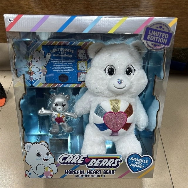 Care Bears Gold Bear et Snow White Ensemble de Jouets en Peluche Ours de Soins, Mettant en Vedette un Ourson Doré et un Ourson Blanc Neige. l'Ours Blanc Neige a un Emblème de Cœur Coloré sur Sa Poitrine et Est Livré avec un Ourson Argenté Métallique Plus Petit. Emballé dans une Boîte Édition de Collection avec un Certificat d'Authenticité. Convient aux Enfants de 3 à 6 Ans.