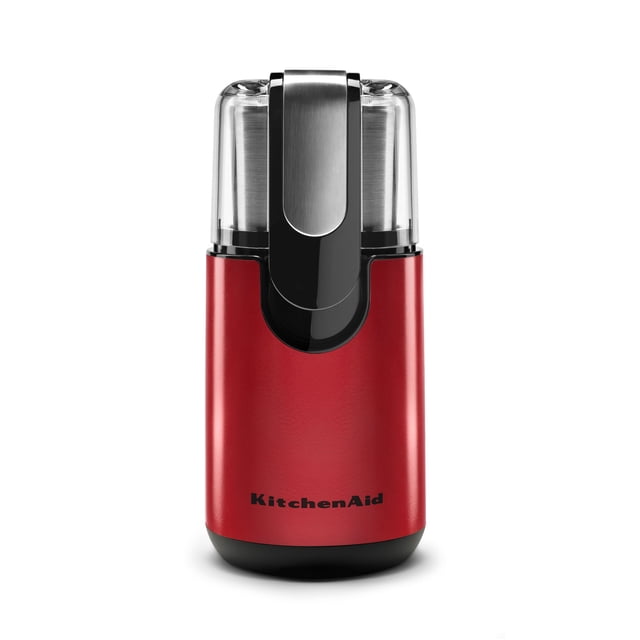 KitchenAid® Blade Coffee Grinder in red with stainless steel blade and clear cover, front view showing one-touch control and measurement markings on the 4 oz bowl, designed to grind whole coffee beans for up to 12 cups and also suitable for grinding spices.