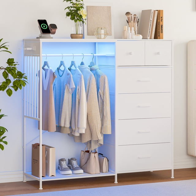 BeesClover 49.2-inch wide dresser with hanging rack and LED lights, featuring six fabric drawers and a reversible wood top. The dresser includes a full-width hanging rack illuminated by customizable LED lights, a built-in charging station with two AC outlets and two USB ports, and a lifted base for shoe storage. The sturdy iron frame and anti-tip design ensure safety, while the mesh panel provides additional storage. Shown in a modern bedroom setting with clothes hanging, shoes, and accessories neatly organized.