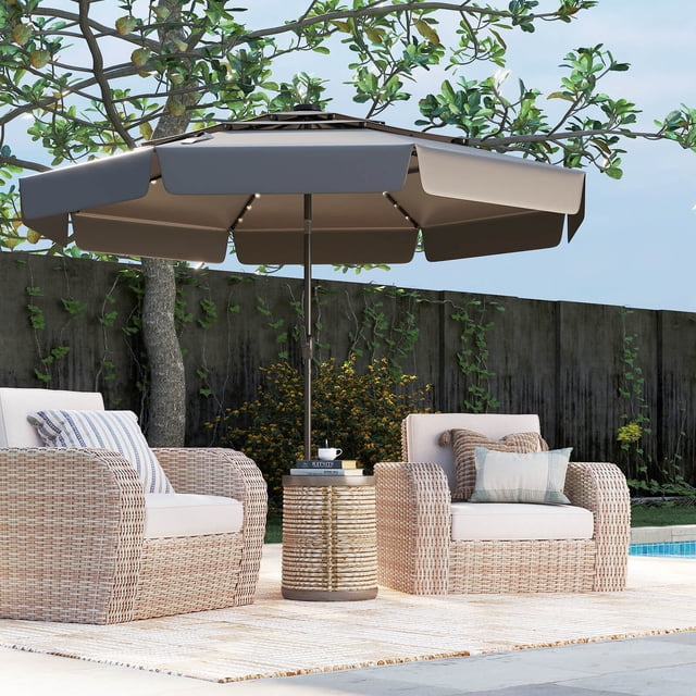 Costway 10 FT Solar Patio Umbrella with 32 LED Lights in gray, featuring a 3-tier vented top and ruffled edges for enhanced airflow and sunshade. The umbrella is shown in an outdoor setting with wicker chairs and a side table, providing shade and ambiance. The 32 LED lights, powered by a solar panel, are evenly distributed along the ribs, offering illumination for up to 6-8 hours. Made with durable polyester fabric, it is sun-protective, water-repellent, and fade-resistant. The umbrella includes a push-button tilt function and a crank handle for easy operation.