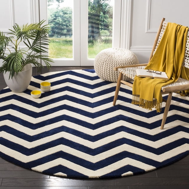 Safavieh Chatham Jake Tapis à Rayures Zigzag de Forme Ronde avec Rayures Zigzag Bleu Marine et Blanc, Laine Tuftée à la Main avec Poil Moyen Moelleux, Exposé sur Plancher de Bois Franc Foncé dans une Pièce Lumineuse avec une Chaise Tissée Drapée d'Un Jeté Jaune Moutarde et un pouf Tricoté Blanc, Convient pour Rehausser les Espaces de Vie Contemporains avec Confort et style.