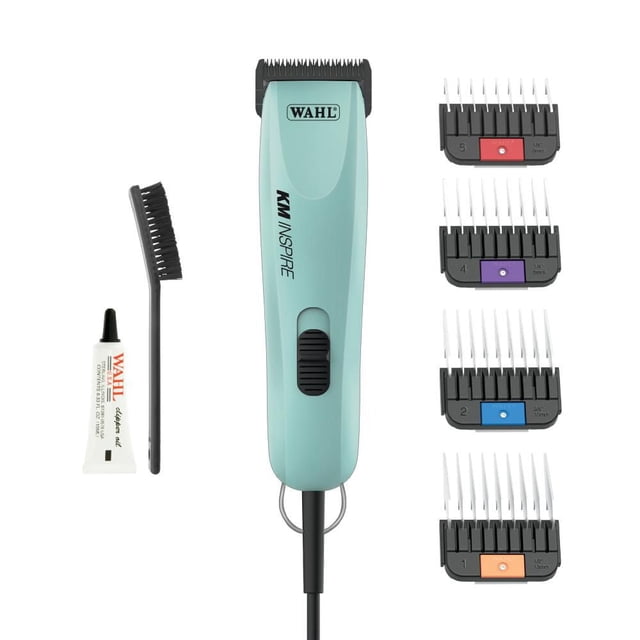 Wahl Professional KM Inspire Corded Animal Clipper in light blue with black blade and power switch, displayed with four numbered guide combs, clipper oil, and cleaning brush on white background, suitable for all coat types and easy blade changes during dog grooming.