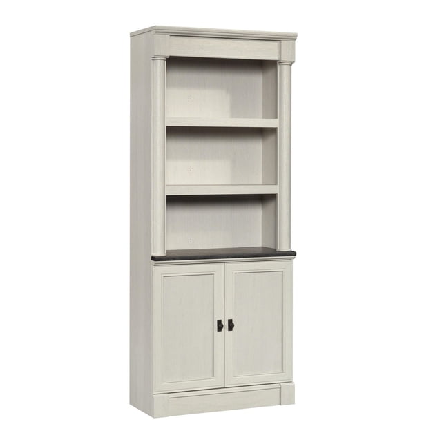 Sauder Palladia® Bibliothèque avec Portes Présentant un design Haut et Élégant avec une Finition Bois Clair. la Bibliothèque Comprend Trois Étagères Ouvertes, Deux d'Entre-Doigts Réglables, et une Armoire Inférieure avec Doubles Portes pour Rangement Caché. les Portes à Panneaux Encadrées et la Quincaillerie en nickel Ajoutent une Touche Classique. Idéale pour le Rangement Multi-Pièces, Elle Comprend un Accès au Cordon et un kit d'Ancrage Mural pour la Sécurité.