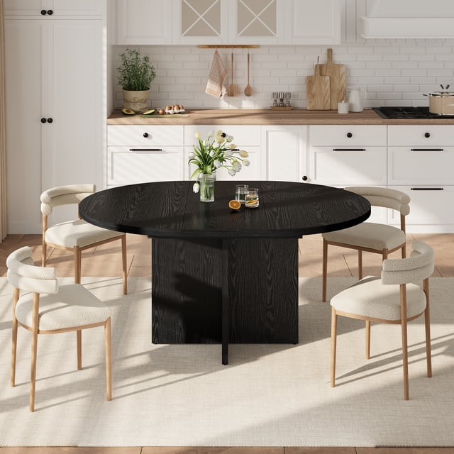 Extendable Round Dining Table 43.3"–59", displayed in a modern kitchen with white cabinetry. The table has a black engineered wood finish, a round-to-oval expandable design, and seats 4–8 people. It features a sturdy cross wood base and is paired with four beige upholstered chairs on a neutral rug. Suitable for dining rooms, kitchens, or living rooms, its compact design is ideal for small spaces.