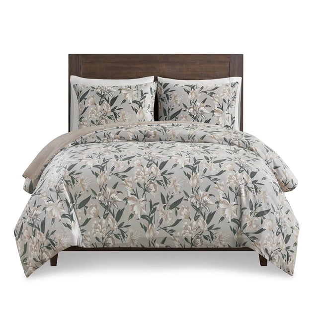 Home Trends Ensemble de Housse de Couette 3 Pcs en Vison Gris avec un Imprimé floral de Fleurs beige et Blanches et de Feuilles Vertes sur Tissu faux Vison 100 % polyester. Comprend une Housse de Couette avec Attaches Intérieures pour Tenir l'Insertion et Deux Taies d'Oreiller Assorties avec Fermetures Enveloppe, Illustré sur un Cadre de Lit en Bois.