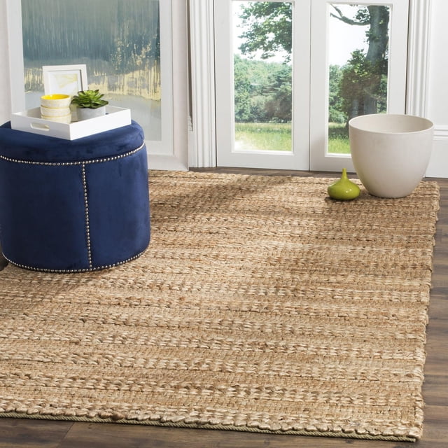 Safavieh Tapis en Fibres Naturelles Henrika Tressé en beige Naturel Tissé à Partir de Fibres de sisal Durables, Posé sur un Plancher de Bois Franc Foncé Près de Portes en Verre à Cadre Blanc avec Verdure Extérieure, Assorti à un ottoman Rond Bleu Marine avec Montants Argentés et Plateau Décoratif, Idéal pour les Intérieurs Côtiers Ou Décontractés.