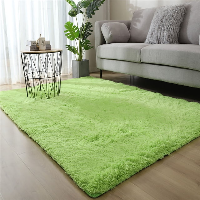 Round Velvet Area Rug with Non-Slip Bottom, 80x200cm, shown in a contemporary living room. The vibrant green velvet rug enhances the wooden flooring and pairs well with the grey sofa and modern decor. Suitable for bedrooms, living rooms, or as a stylish accent piece.