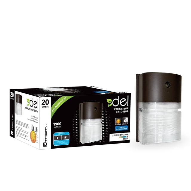 Xtricity Lumière de Sécurité Extérieure DEL 20W/5000k/1900L Montrée avec Son Emballage. Ce Projecteur Présente une Conception Résistante aux Intempéries, une Luminosité de 1900 lumens et une Température de Couleur de Lumière du Jour de 5000K. Il s'Allume Automatiquement au Crépuscule et s'Arrête à l'Aube, Idéal pour les applications d'Éclairage Extérieur.