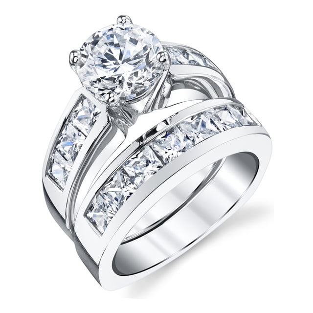 Ensemble Nuptial en Argent Sterling pour Femme Comprenant une Bague de Fiançailles en Zircon Cubique Taille Ronde de 2 Ct Assortie à un Alliance Assorti. l'Ensemble Est Fabriqué en Argent Sterling 925 avec Placage rhodium pour une Finition Ton Or Blanc. la Bague de Fiançailles Met en Valeur une Pierre Centrale Sertie de Griffes, Tandis Que les Deux Bagues Sont Ornées d'Accentures en Zircon Cubique Taille Princesse Serties en Rail. le Poids Total en carat Est de 3,35 Ct. Comprend une Boîte-Cadeau