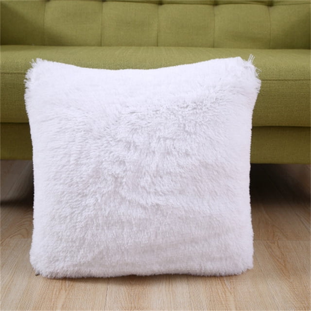 Agiferg short plush pillow cover in solid white color, measuring 43x43cm, displayed in front of a green sofa on a wooden floor. The soft and fuzzy texture of the pillow cover is ideal for home décor, suitable for sofas, beds, or living rooms. Made of artificial plush, it adds warmth and style, especially in autumn and winter.