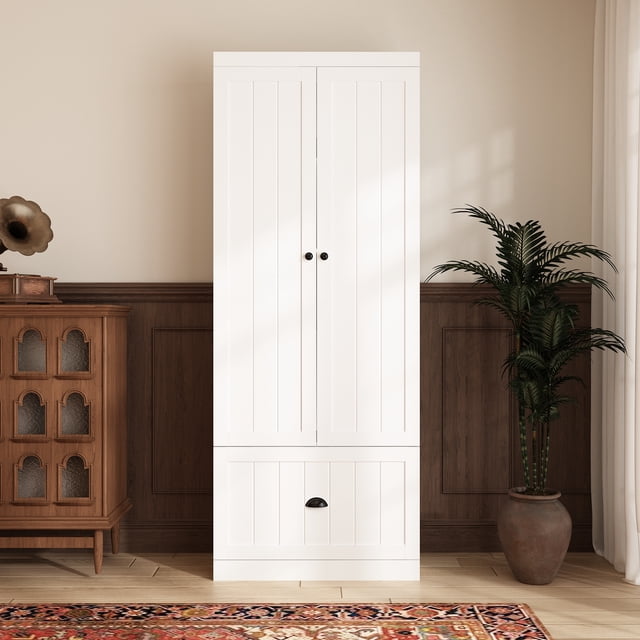 OXYLIFE 70.9"H Kitchen Pantry Storage Cabinet with Drawer and Adjustable Shelves in white. This freestanding cabinet features double-door cabinets, a large drawer, and adjustable shelves for versatile storage. Ideal for organizing dishes, small appliances, and pantry items. Includes an anti-tip device for added safety. Shown in a cozy interior setting with wood paneling, a potted plant, and a vintage cabinet nearby.