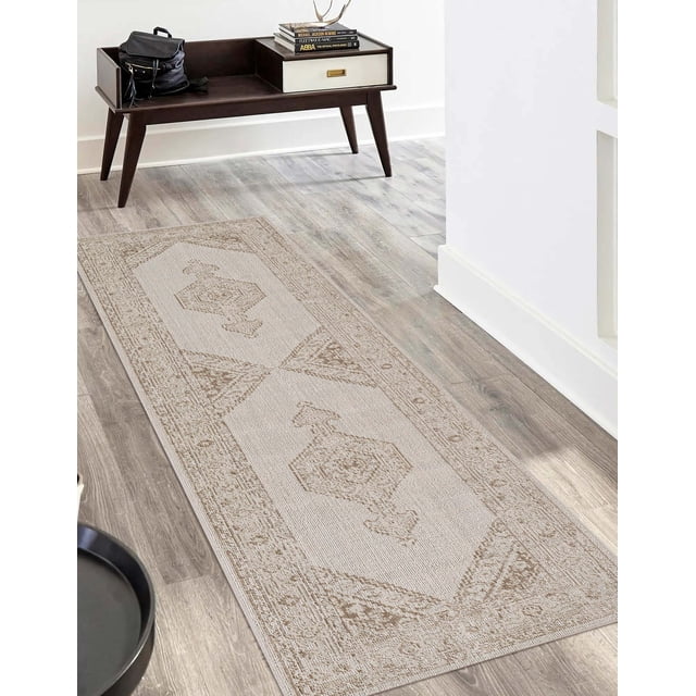 ECARPET Maude Traditional Runner Rug in soft beige and warm neutral tones with classical geometric patterns, machine-made in durable polyester for high traffic areas, placed on light wood flooring in a hallway with a dark wood bench holding books and a black bag, also suitable for entryways and dining rooms.