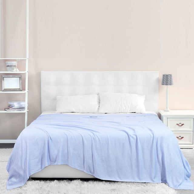 PiccoCasa Cooling Blanket Viscose from Bamboo Breathable Light Blue Queen displayed on a neatly made bed in a modern bedroom. The light blue blanket, made from 100% viscose derived from bamboo, features a soft, breathable, and lightweight design. The fabric is cool to the touch and helps regulate body temperature by absorbing and dissipating heat, making it ideal for year-round use. The bed is styled with white pillows and a tufted white headboard, with a nightstand and lamp visible in the background.
