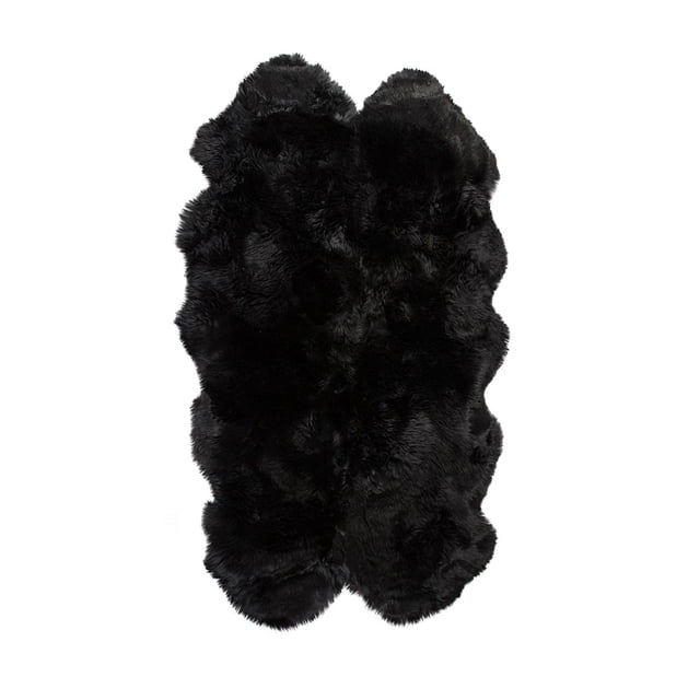 NEW ZEALAND SHEEPSKIN QUATTRO RUG 4' X 6' in black with an ultra-thick 2.5-inch natural sheepskin pile, dense and plush texture, irregular quatrefoil shape, and soft micro suede anti-skid backing designed for indoor use and high-traffic areas, often used as a cozy seat cover or draped accent.