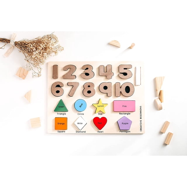 Creative Beginning Wooden Preschool Puzzle for Kids Ages 3-5 with Tracers & Chalkboard Base featuring wooden numbers 1 to 10 in neutral tones and colorful shape pieces labeled with color and shape names including green triangle, blue circle, yellow star, pink rectangle, orange square, white diamond, red heart, and purple pentagon on a 16 by 12 inch light wood board, surrounded by small wooden blocks and dried flowers.