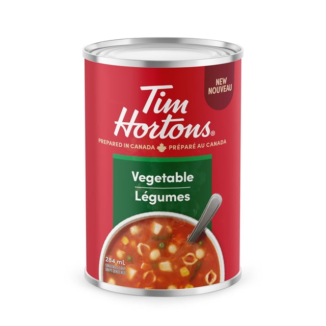 TIM HORTONS VEGETABLE CONDENSED SOUP in a red metal can with silver top, showing the Tim Hortons logo and bilingual label stating it is prepared in Canada. The label features a bowl of vegetable soup with pasta shells, corn, peas, and diced vegetables, indicating 284 mL condensed canned soup. This vegetarian, low-fat soup contains no artificial colours or flavours and is ideal for pantry storage.