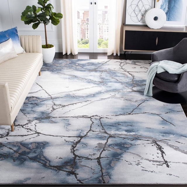 SAFAVIEH Craft Paul Abstract Marble Area Rug featuring swirling blue and gray marble-inspired abstract patterns with subtle etched pile texture, displayed on dark hardwood flooring between a cream sofa and gray armchair in a contemporary living room, ideal for adding modern style and comfort to home spaces.