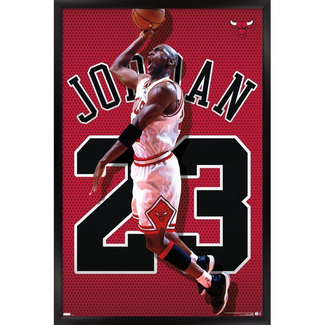 Michael Jordan - Jersey Wall Poster, 22.375" x 34" framed, depicting Michael Jordan in a white Chicago Bulls jersey number 23, jumping with a basketball against a red perforated background with large black number 23 and 'JORDAN' text, framed in black with the Bulls logo, suitable for sports-themed room or office decor.