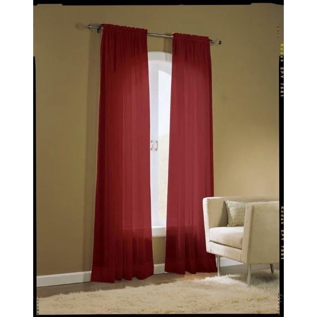 No. 918 Voile Pole Top Curtains in deep red, sheer crushed voile panels with rod pocket tops and 5-inch bottom hems, measuring 59 by 63 inches. Shown hanging on a silver rod over a white arched window in a beige room with a cream armchair and white rug, suitable for light filtering and decorative window treatments.