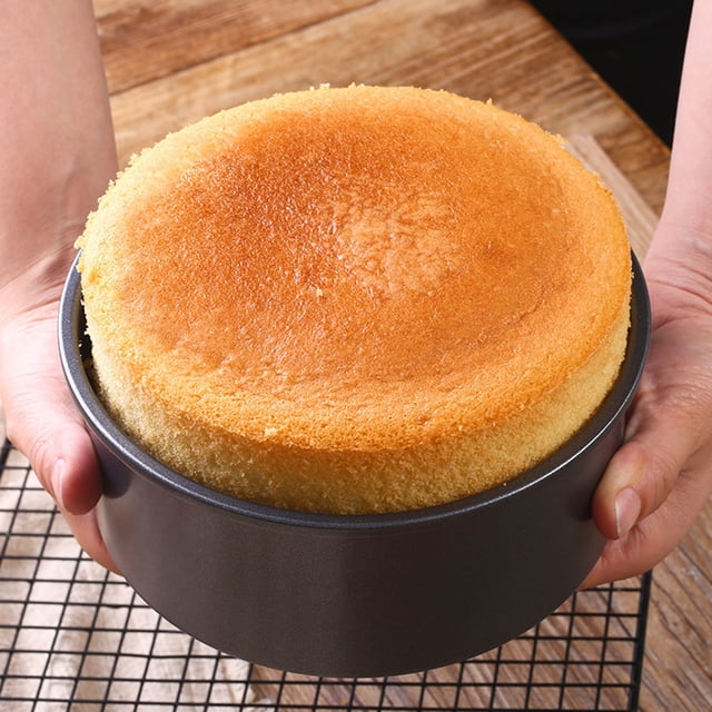 Dvkptbk Cake Moulds Factory Direct Cake Baking Pan made of durable metal with a non-stick coating, shown holding a freshly baked golden cake. The round pan measures 21.5x21.5x6.5 cm (8.46x8.46x2.56 in) and is designed for even heat distribution, making it ideal for DIY baking projects. The image highlights its easy-release feature, perfect for creating cakes for family gatherings, birthdays, or travel.