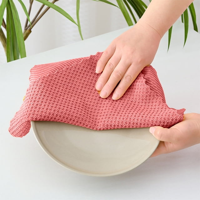 EGNMCR Multi Functional Kitchen Cleaning Cloth with 4 pcs of ultra fine fiber cleaning cloths shown in use. A hand is wiping a white plate with a red textured polyester cloth. The cloth features a unique pattern for effective scrubbing and is designed to be soft and gentle on surfaces. Ideal for cleaning dishes, countertops, and appliances.