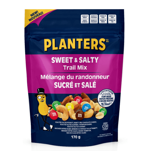 Planters Sweet & Salty Trail Mix 170 g resealable bag featuring roasted salted peanuts, M&M's milk chocolate candies, roasted salted almonds, Thompson raisins, and roasted salted cashews. The navy blue and magenta packaging includes bilingual English and French text with nutrition highlights and the Mr. Peanut mascot. Ideal for snacking or outdoor activities.