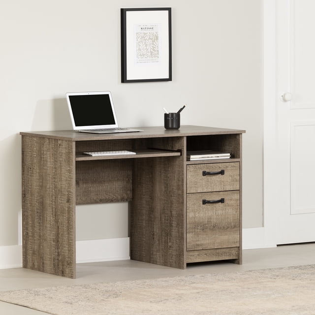South Shore Tassio Desk Nordik Oak medium desk with textured Nordik oak laminated particleboard finish, pull-out keyboard shelf, two drawers with vintage metal handles, and open storage, shown in a neutral room with a laptop and pen holder, ideal for home office or study.