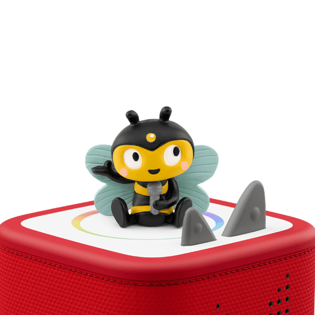 Tonies Favorite Songs Bugs Audio Figurine featuring a multicolour bee character with black and yellow stripes, blue wings, and pink cheeks, holding a grey microphone, sitting on a red and white Toniebox audio player with textured fabric sides and two grey control knobs, designed for educational music play for kids.