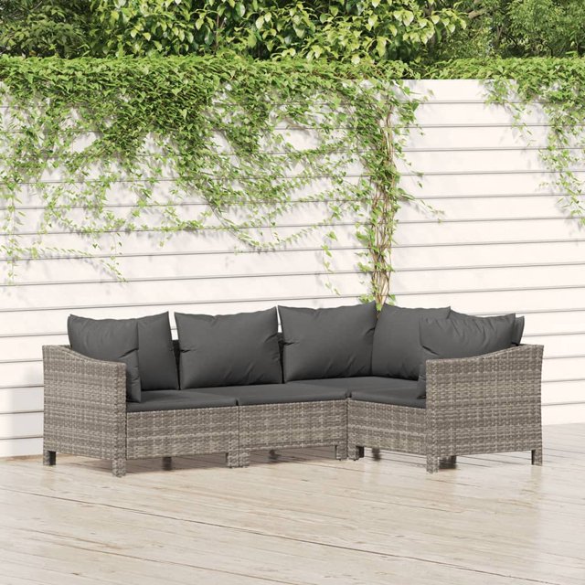 vidaXL Ensemble de Salon de Jardin 4 Pcs avec Coussins en Rotin poly Gris, Présentant un design Modulaire avec un sofa à Accoudoir Gauche, un sofa à Accoudoir Droit, un sofa d'Angle et un sofa Central. l'Ensemble Comprend des Coussins en polyester Gris Foncé pour un Confort Accru. Fabriqué avec du Rotin PE Résistant aux Intempéries et un Cadre en Acier Enduit de Poudre pour la Durabilité, Il Convient à une Utilisation Extérieure. Montré sur un patio en Bois avec une Clôture Blanche et de la Verdure en Arrière-Plan.
