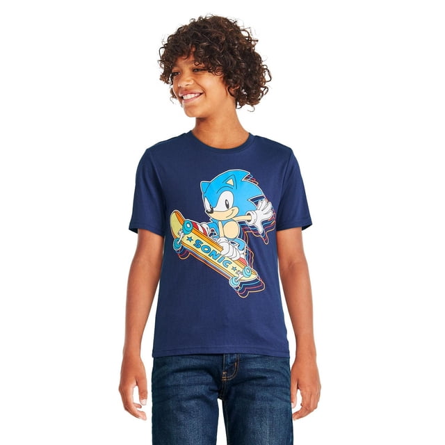 Sonic The Hedgehog T-Shirt à Manches Courtes pour Garçons en Bleu Marine avec une Impression Graphique de Sonic Chevauchant une Planche à Roulettes avec le Mot « Sonic », Fabriqué en Tricot jersey Doux avec Encolure Ras du Cou, Manches Courtes et Ourlet Droit, Assorti à des jeans Bleu Foncé pour Tenue Décontractée.