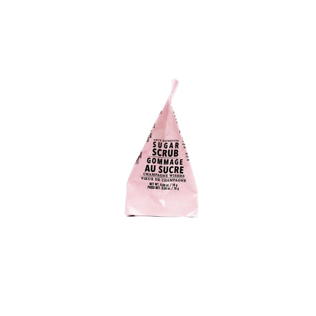 Onyx Champagne Wishes Sugar Scrub Minis in a pink 1oz travel-size packet with black text, gently exfoliating and hydrating skin with jojoba oil, ideal for travel size body care and all skin types.