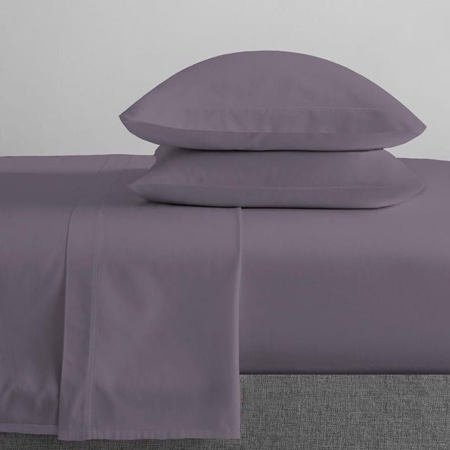 Johnson Home 450 Thread Count Bamboo Bed Sheet Set in muted purple, showing a smooth, wrinkle-resistant flat sheet and two matching pillowcases stacked on a grey fabric bed base, made from breathable, hypoallergenic bamboo fabric for year-round comfort.