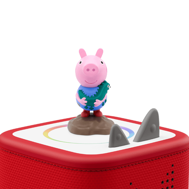 tonies Peppa Pig: George Audio Play Figurine showing a front-facing pink pig character in a blue shirt holding a green dinosaur, standing on a brown base atop a red Toniebox speaker with white top panel and grey control ears, ideal for screen-free educational play.