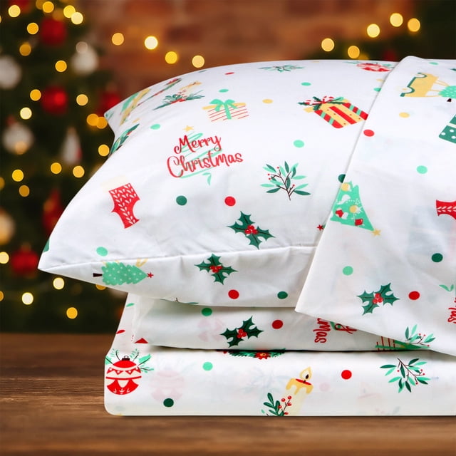 Hitime Ensemble de Draps de Noël Très Grand Size 4 Pcs Comprenant un Tissu en polyester Ultra Doux et Respirant avec un Petit Motif Festif de Noël. l'Ensemble Comprend un Drap Plat, un Drap-Housse avec des Poches Profondes pour Matelas jusqu'à 16 Pouces, et Deux Taies d'Oreiller. le Matériau en Microfibre Résistant aux Plis et à la Décoloration Assure la Durabilité et le Confort pour Toutes les Saisons. Exposé dans un Décor des Fêtes Douillet avec un Sapin de Noël en Arrière-Plan.