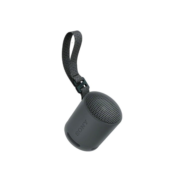 XB100 Compact Bluetooth® Speaker in matte dark gray with cylindrical shape and perforated metal grille on top, featuring a woven carrying strap with black plastic clip and Sony logo on the side, designed for portable wireless audio use.