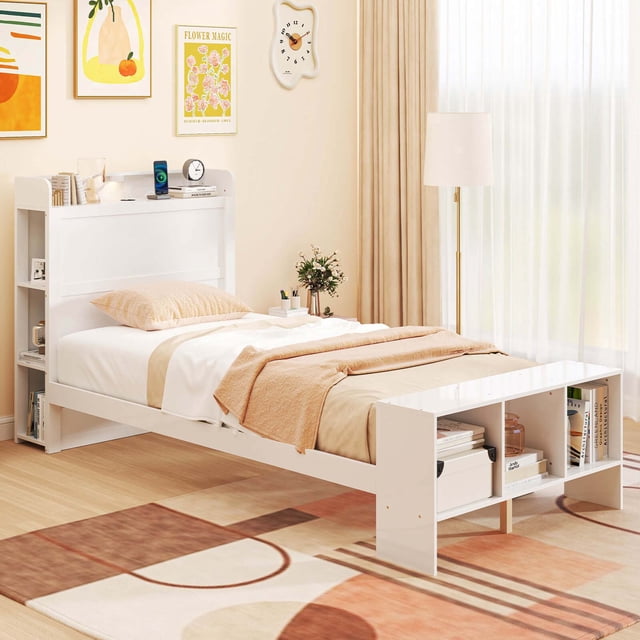 Costway Twin Size Bed Frame with Storage Headboard & Footboard LED Bed Frame with 2 USB Ports in a modern bedroom setting. The white wooden bed frame features built-in storage shelves on the headboard and footboard, ideal for books and essentials. The headboard includes 2 USB ports for convenient device charging. The bed frame is equipped with adjustable LED lights offering three color options (white, light yellow, dark yellow) to create a cozy ambiance. The sturdy construction includes solid pine wood and plywood slats, supporting up to 330 lbs. Ample under-bed space provides additional storage. Shown with a neatly made bed and decorative accents in a bright, minimalist room.