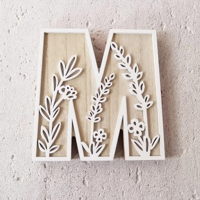 5 Inch Wooden Letter 'M' for wall decoration, crafted from natural wood with white floral cutout designs. Perfect for creating name signs, decorating rooms, weddings, or home projects. Lightweight and customizable for painting or personalizing, suitable for LED bar lights and novelty lighting setups.